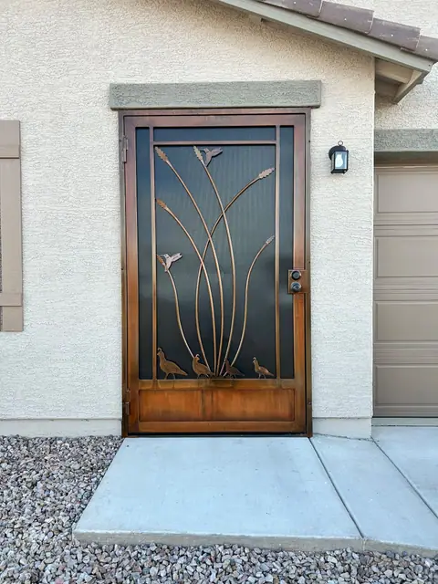 Security door with cut steel desert reeds and quail in a copper finish